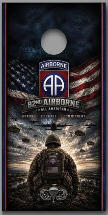 Two matching cornhole board designs shown side by side on a gray background. Each board features a military-themed graphic with an American flag, the text 'Airborne 82nd All American,' parachutist silhouettes, and a soldier seen from behind under a stormy sky.