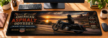 American Asphalt Odyssey Desk Mat in use on a warm wood office desk — overhead workspace view