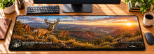 Backcountry Mule Deer Vista Desk Mat in use on a warm wood office desk — overhead workspace view