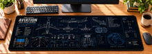 Blueprints of Flight Desk Mat in use on a warm wood office desk — overhead workspace view
