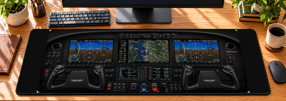 Modern Glass Cockpit Aviation Desk Mat in use on a warm wood office desk — overhead workspace view