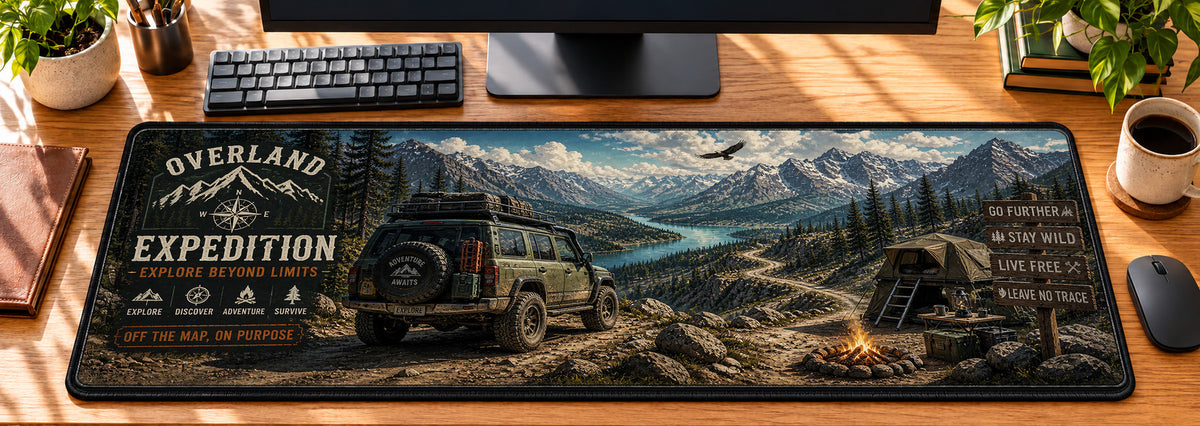Overland Off-Road Expedition Desk Mat in use on a warm wood office desk — overhead workspace view