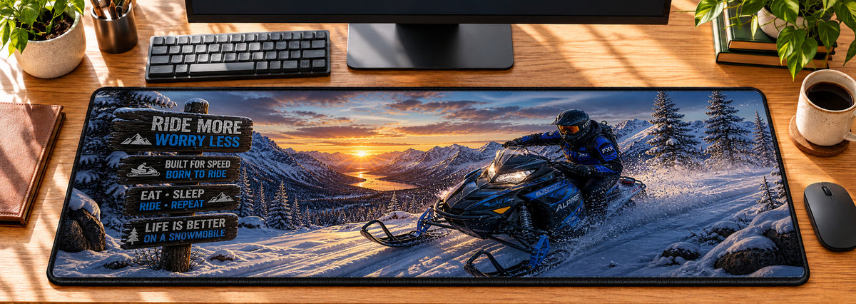 Snowmobile Alpine Rush Desk Mat in use on a warm wood office desk — overhead workspace view
