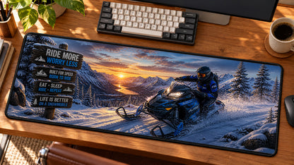 Snowmobile Alpine Rush Desk Mat in use on a warm wood office desk — angled workspace view