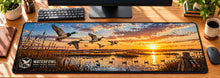 Waterfowl Marsh Flight Desk Mat in use on a warm wood office desk — overhead workspace view