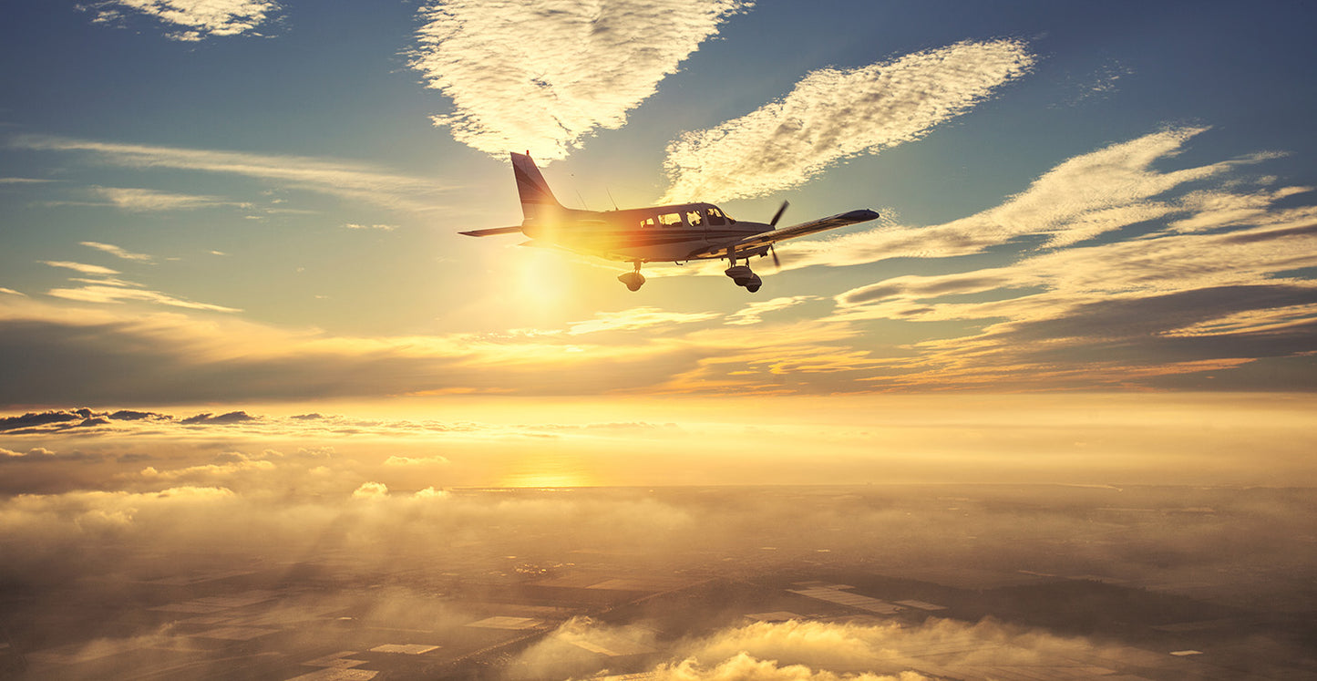 Small Airplane Flying at Sunset Clouds Wall Mural